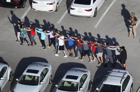 People are brought out of the Marjory Stoneman Douglas High School after the shooting. 