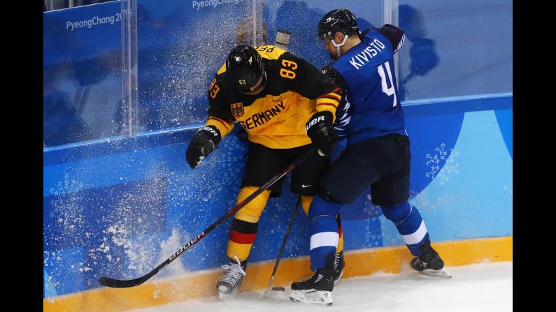 Germany's Leonhard Pfoderl, left, and Finland's Tommi Kivisto battle for the puck during a preliminary round game.