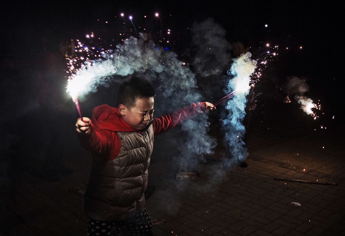 A boy uses sparklers to celebrate the Chinese Lunar New Year in Beijing, in 2005. 