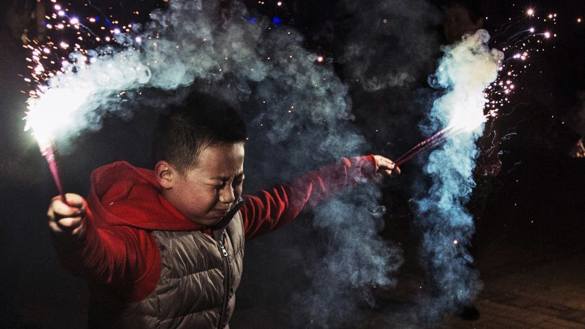 A boy uses sparklers to celebrate Chinese Lunar New in Beijing, China (2005). In China, fireworks were traditionally used to ward off evil spirits. 