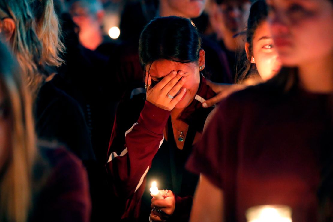 A woman cries during a candlelight vigil for the victims of the shooting at Marjory Stoneman Douglas High School