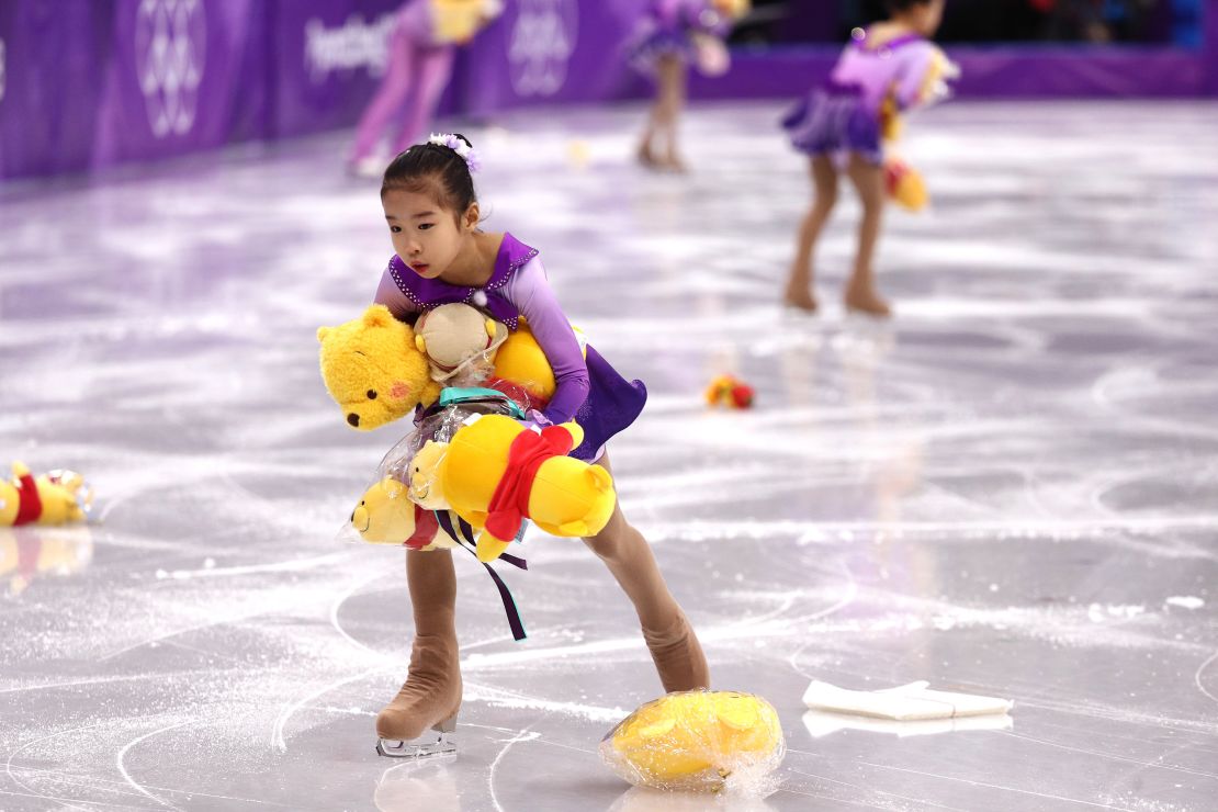  Skaters pick up gifts thrown to the ice for Yuzuru Hanyu of Japan during the men's single kkating short program at the Gangneung Ice Arena.