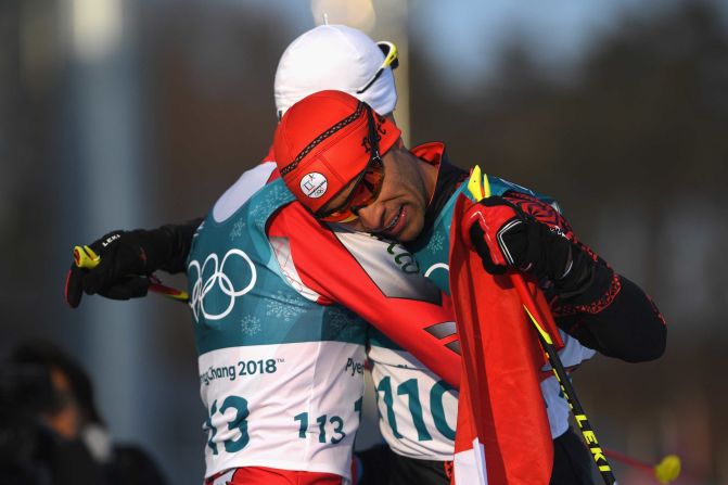 Tonga's Pita Taufatofua, right, hugs Morocco's Samir Azzimani after finishing the 15-kilometer freestyle. Taufatofua is most known for going shirtless during the last two opening ceremonies. He competed in taekwondo at the Rio Summer Games in 2016.