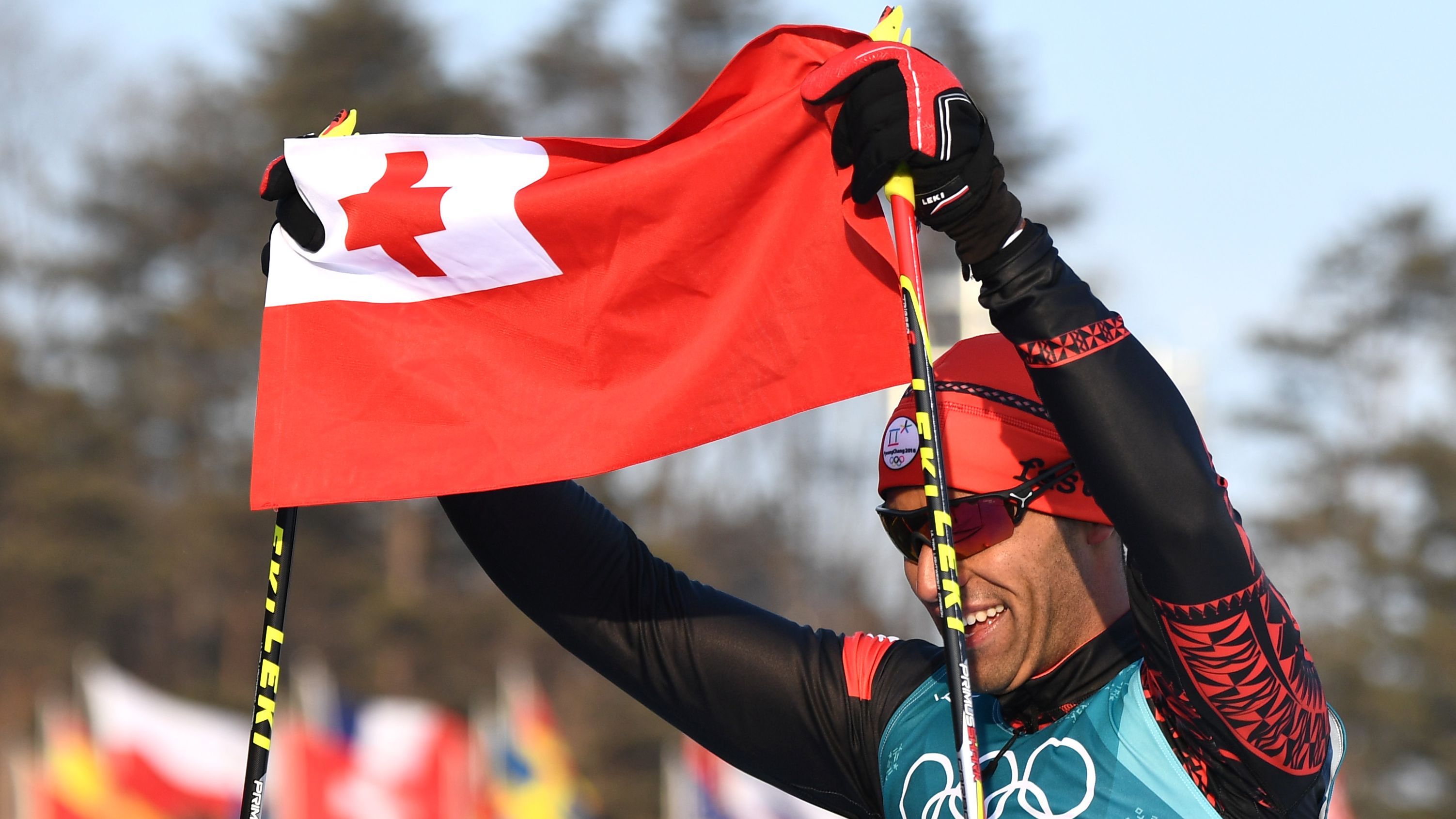 Taufatofua holds up his national flag after his Winter Olympic debut.