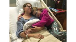 Melissa Murphy, 40, hugging her daughter Brenna while hospitalized at Mercy Hospital in Des Moines, Iowa following her heart attack in 2016.