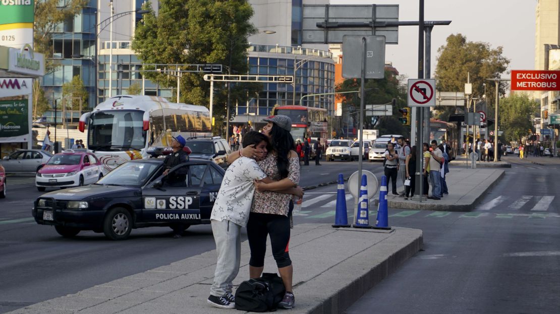 A woman embraces a boy during a powerful earthquake in Mexico City on February 16, 2018.
