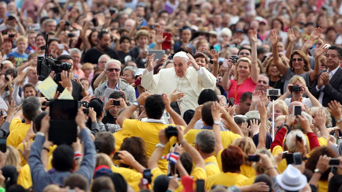 Francis waves to the faithful during a weekly audience at the Vatican in October 2014.