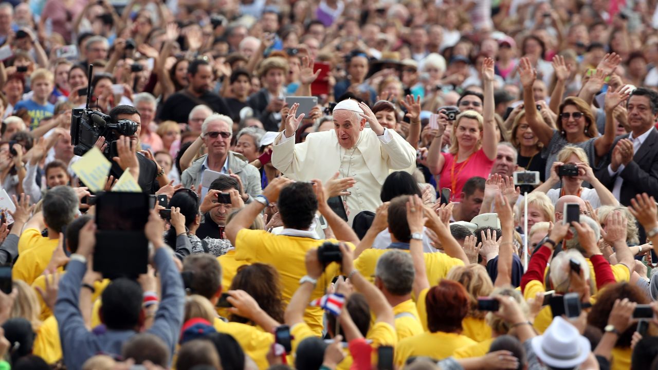 Francis waves to the faithful during a weekly audience at the Vatican in October 2014.