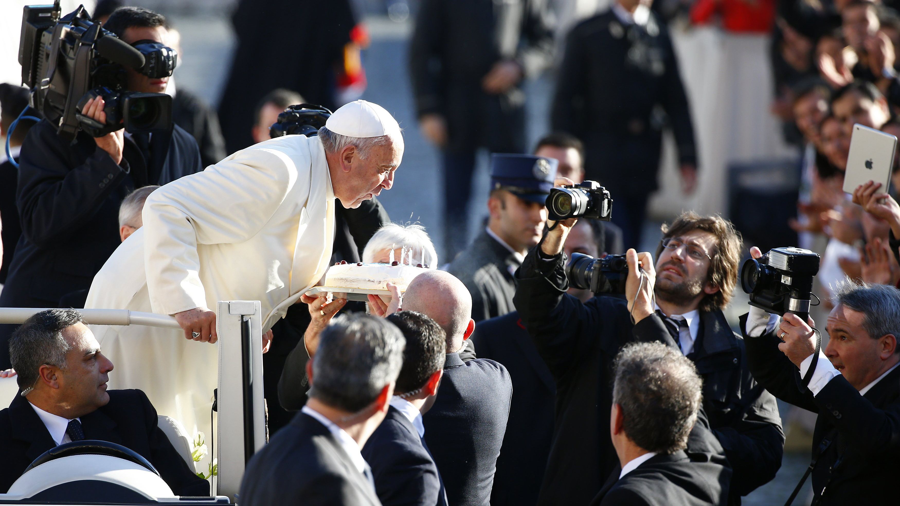 Francis blows out candles on a cake as he celebrated his 78th birthday in December 2014.