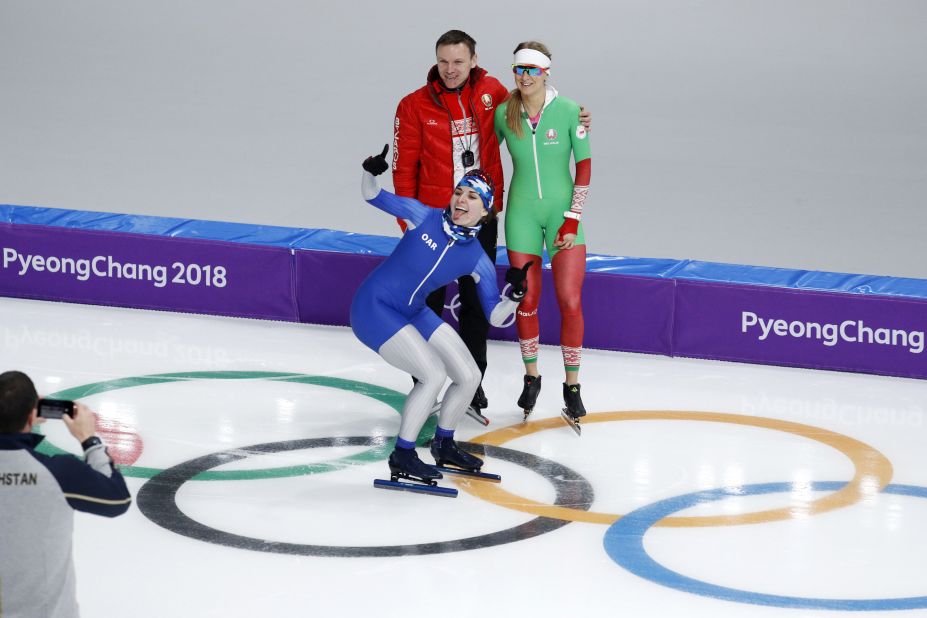 Angelina Golikova, a speedskater from Russia, photobombs teammate Kseniya Sadouskaya and her coach during a practice session.