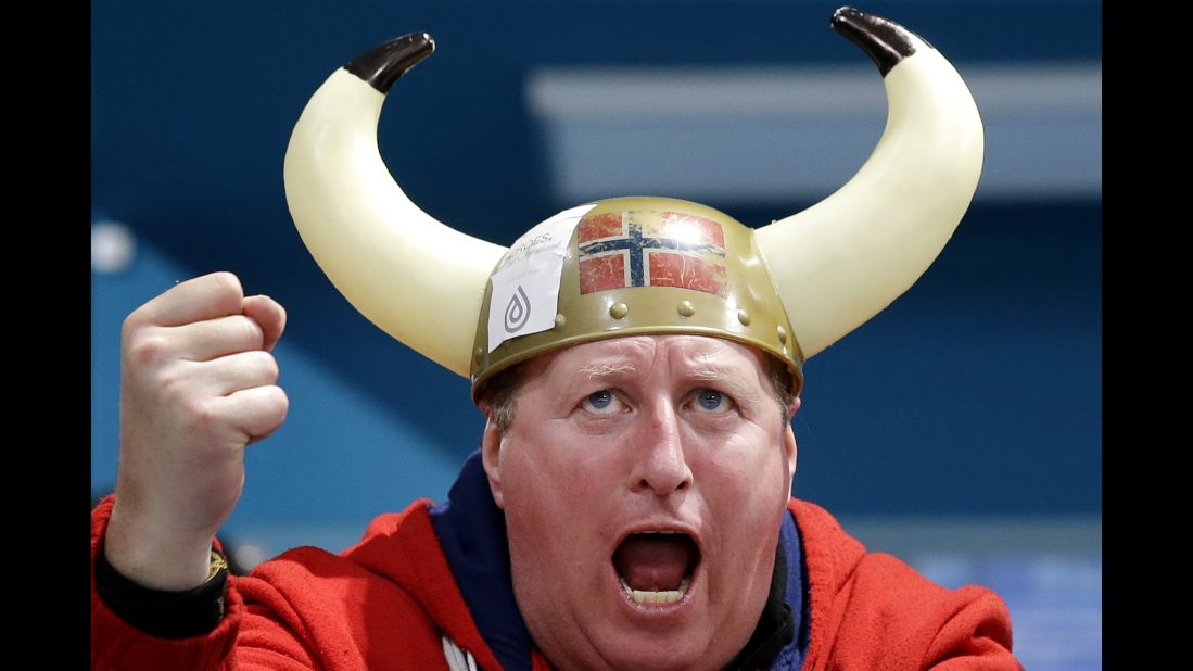 A spectator cheers for Norway during a men's curling match.