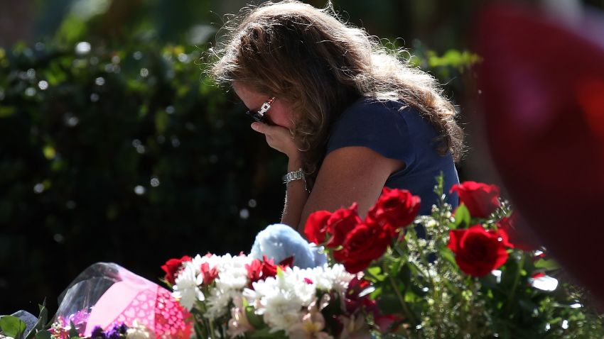 A woman becomes emotional while visiting a temporary memorial at Pine Trails Park on February 17, 2018 in Parkland, Florida. Police have arrested former student Nikolas Cruz and charged him with 17 murders for the shooting at Marjory Stoneman Douglas High School on February 14.