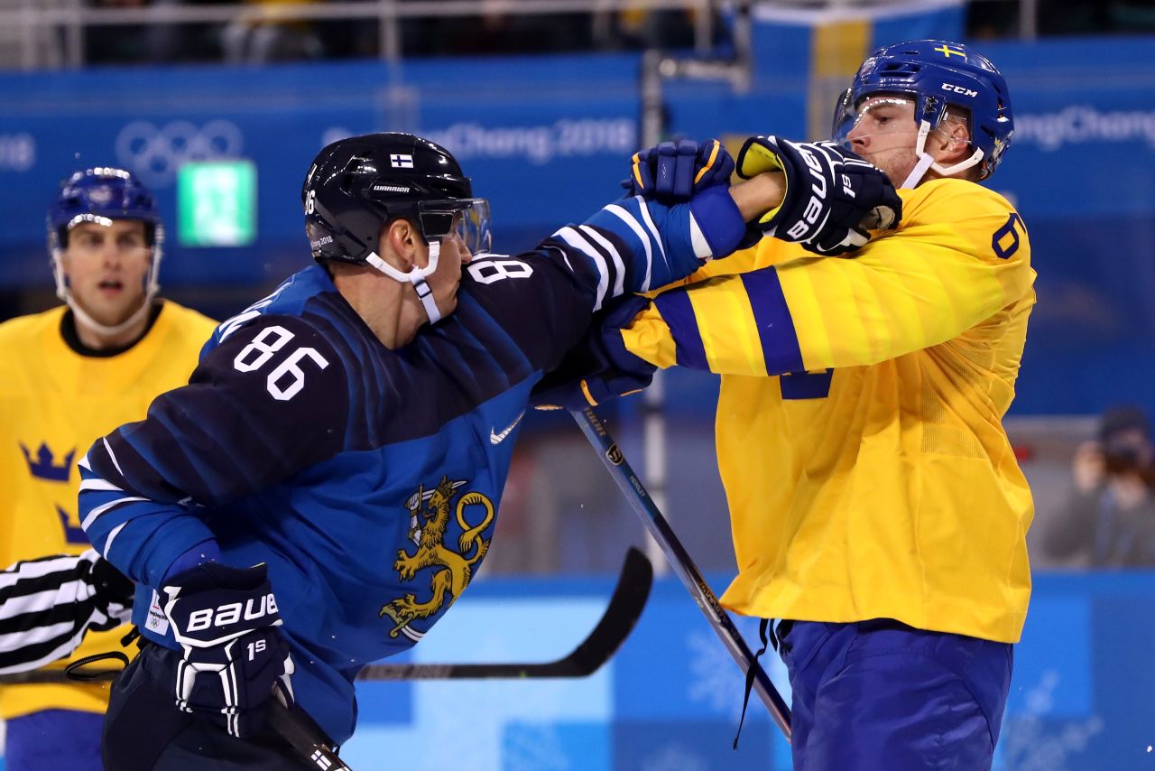 Patrik Hersley, right, of Sweden, and Veli-Matti Savinainen of Finland get tangled up in the first period of their hockey game.