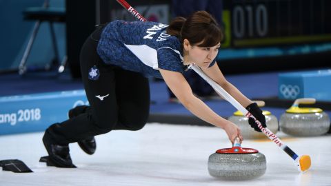 Japan's Chinami Yoshida throws a stone during a curling match against Canada.