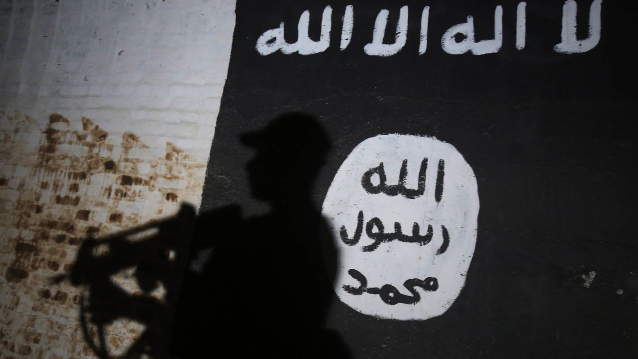 TOPSHOT - A member of the Iraqi forces walks past a mural bearing the logo of the Islamic State (IS) group in a tunnel that was reportedly used as a training centre by the jihadists, on March 1, 2017, in the village of Albu Sayf, on the southern outskirts of Mosul.
Iraqi forces launched a major push on February 19 to recapture the west of Mosul from the Islamic State jihadist group, retaking the airport and then advancing north. / AFP PHOTO / AHMAD AL-RUBAYE        (Photo credit should read AHMAD AL-RUBAYE/AFP/Getty Images)