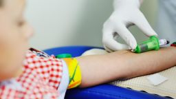 a doctor or nurse takes blood from a vein in a child of a boy. Blood chemistry; Shutterstock ID 771178429