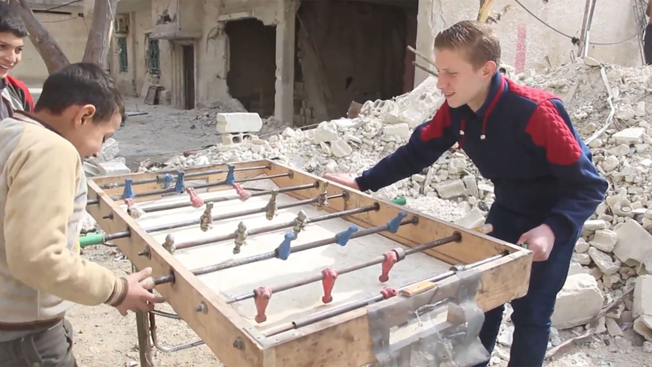 Najem and his friends find a spot of childhood happiness, playing foosball in their bombed out streets.