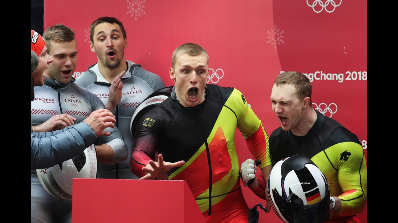German bobsledders Francesco Friedrich and Thorsten Margis, right, react as they watch the final run by Canada's Justin Kripps and Alexander Kopacz. The two teams will share the gold after finishing with the exact time over four runs.