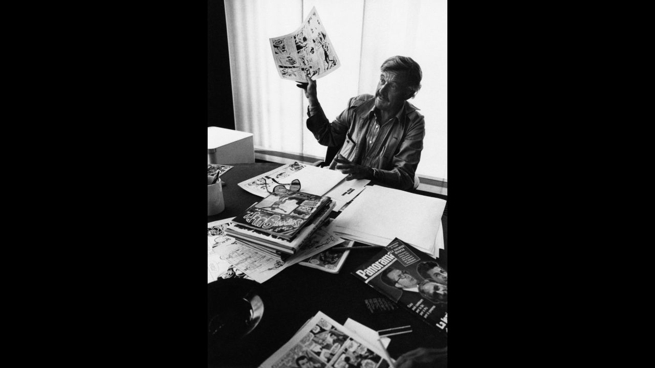 Lee, born Stanley Martin Lieber, holds up comic book art during the 1970s. In 1941, he became the editor at Timely Comics, which evolved into Marvel Comics.