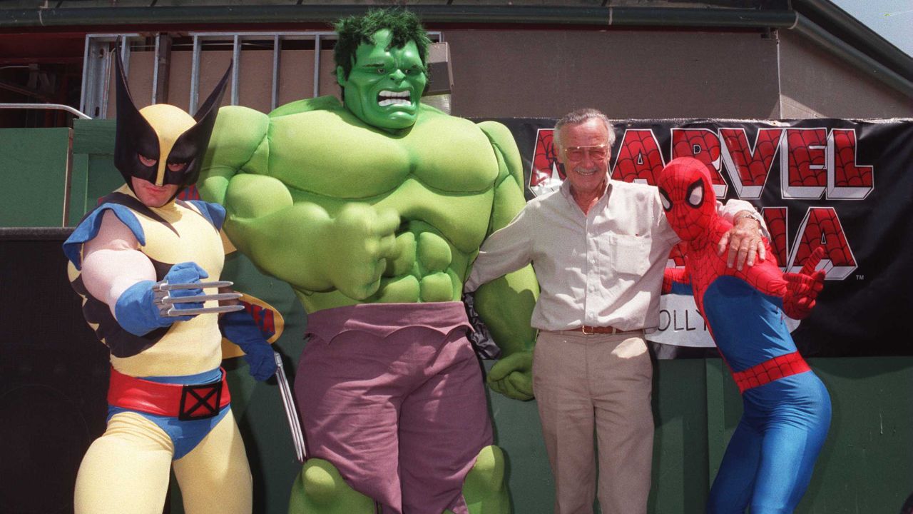 Lee poses with a few Marvel heroes in 1997.