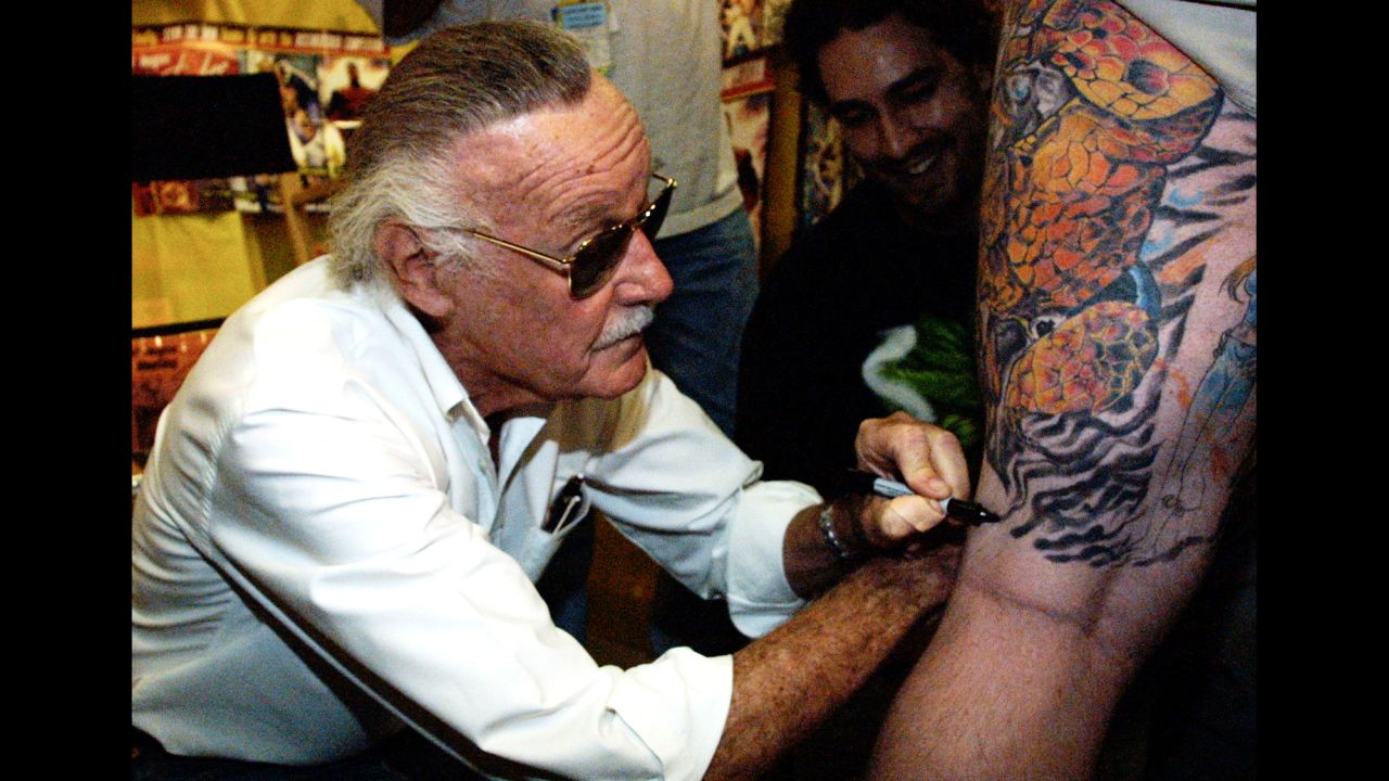 Lee autographs a man's leg during a book premiere in 2001.