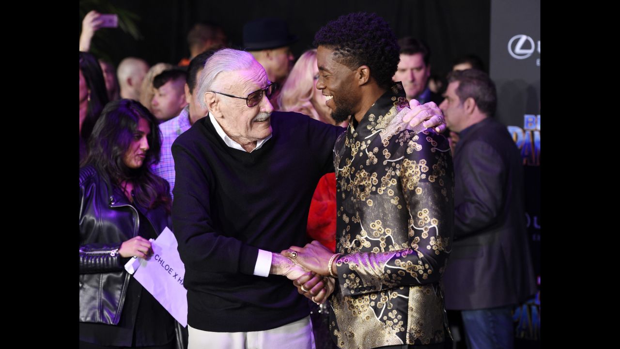 Lee shakes hands with "Black Panther" star Chadwick Boseman at the film's premiere in January 2018.