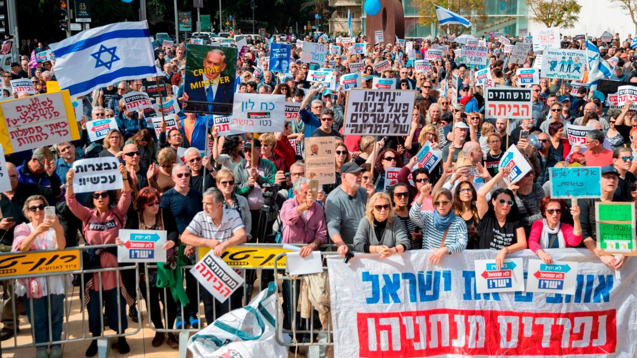 Israeli protesters raise signs as they demonstrate against Prime Minister Benjamin Netanyahu in the wake of police recommendations to indict corruption, in the coastal city of Tel Aviv on February 16, 2018.
