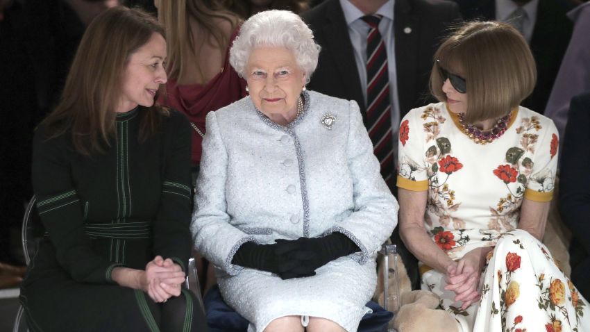 Britain's Queen Elizabeth sits next to fashion editor Anna Wintour, right, and Caroline Rush, chief executive of the British Fashion Council (BFC) as they view Richard Quinn's runway show before presenting him with the inaugural Queen Elizabeth II Award for British Design, as she visits London Fashion Week's BFC Show Space in central London, Tuesday, Feb. 20, 2018. (Yui Mok/Pool photo via AP)