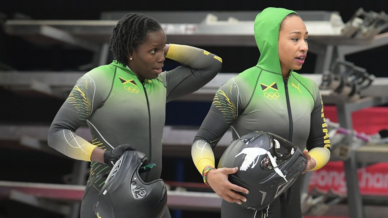 Jamaica's Jazmine Fenlator-Victorian (R) and Jamaica's Carrie Russell walk off the track after the women's bobsleigh heat 2, which has put them in 18th place.