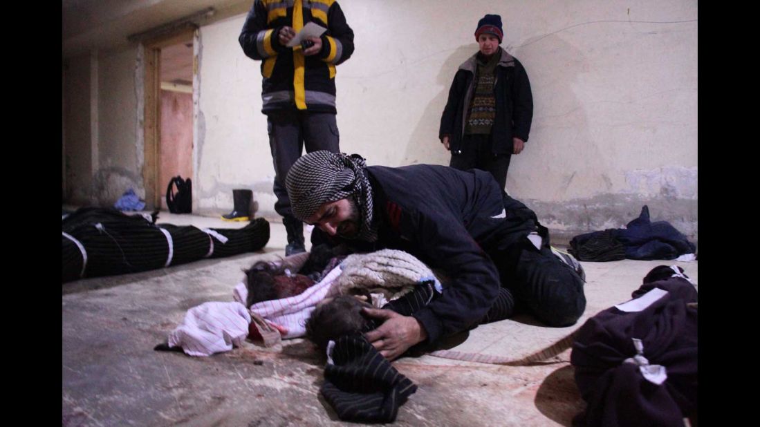 A man weeps over his child, who was killed in the Mesraba airstrikes.