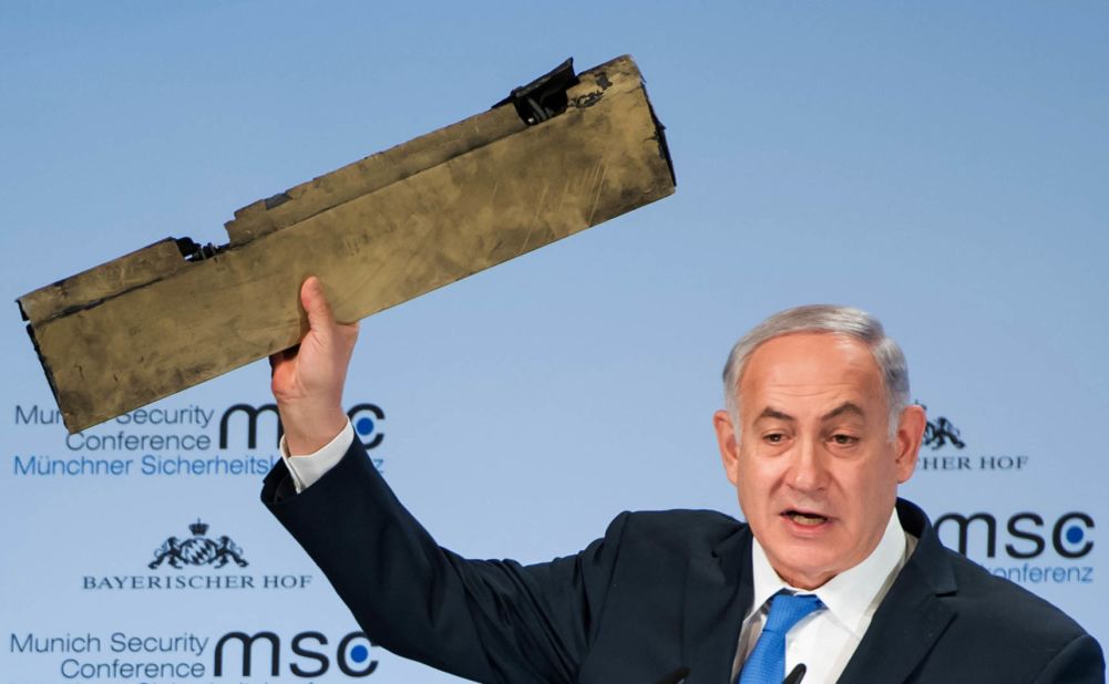 Netanyahu, speaking at a security conference in Germany in February 2018, holds up what he claimed is a piece of an Iranian drone that was shot down after it flew over Israeli territory.