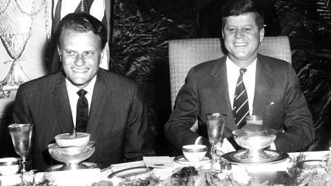 Graham sits with US President John F. Kennedy.