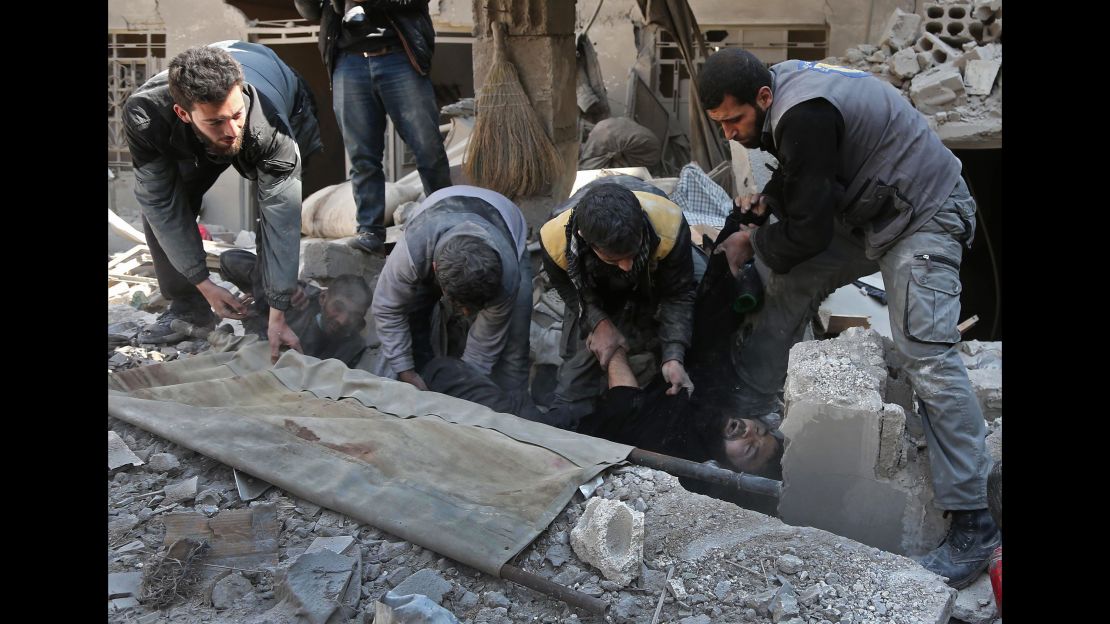 Volunteer rescue workers help a man in Hamurriya, Eastern Ghouta, on Wednesday.