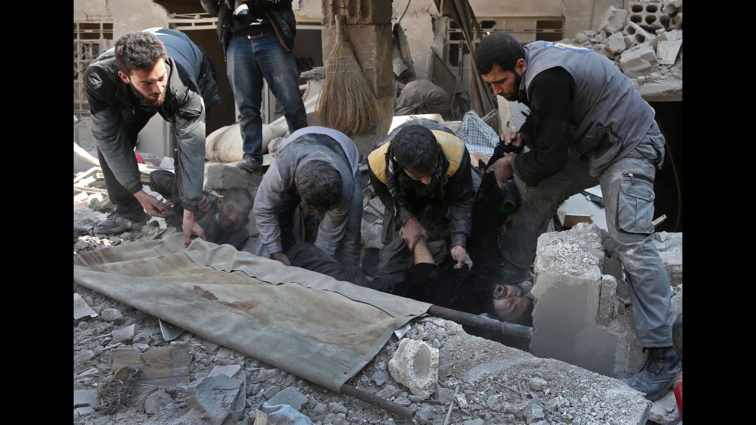 Members of a Syrian civil-defense team rescue a man in Hamouria on February 21.