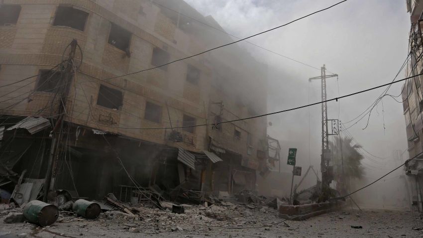 Smoke and dust are seen following a reported regime air strike in the rebel-held town of Hamouria, in the besieged Eastern Ghouta region on the outskirts of the capital Damascus on February 21, 2018. / AFP PHOTO / ABDULMONAM EASSA (Photo credit should read ABDULMONAM EASSA/AFP/Getty Images)