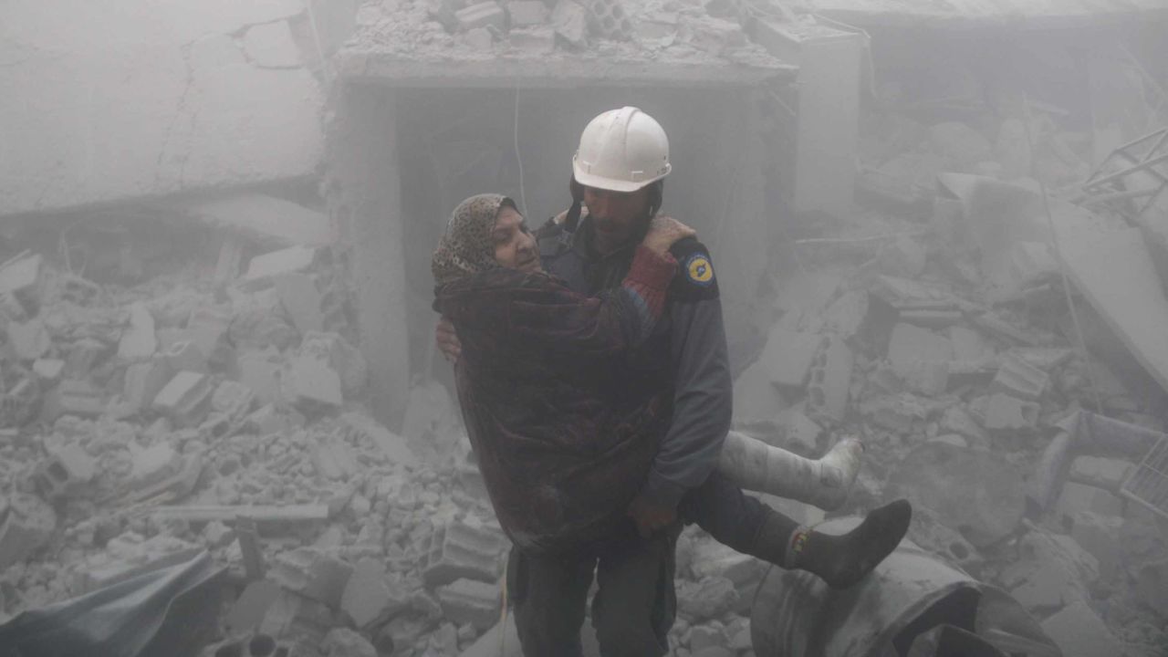 A rescue worker carries a woman from the wreckage of buildings hit by an airstrike over Erbin in Eastern Ghouta on Tuesday.