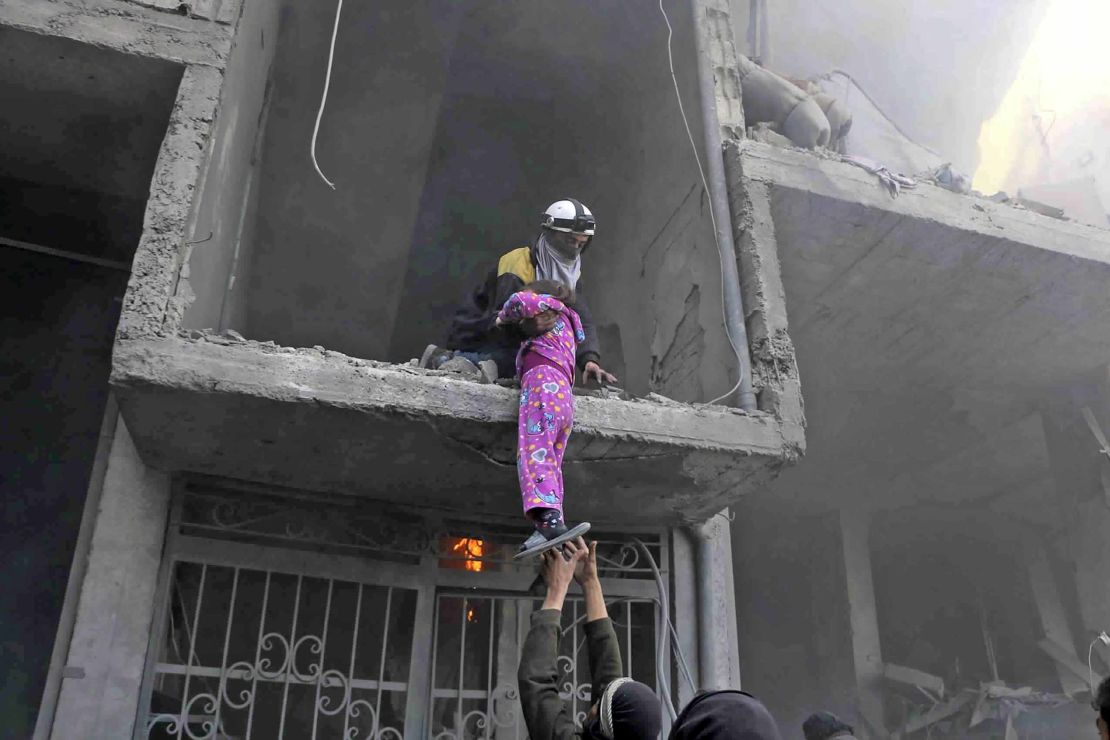 A photo provided Wednesday by the White Helmets volunteer group shows the rescue of a young girl from a building damaged by airstrikes and shelling in Eastern Ghouta.