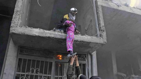 A photo provided Wednesday by the White Helmets volunteer group shows the rescue of a young girl from a building damaged by airstrikes and shelling in Eastern Ghouta.