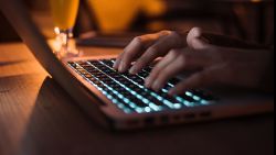 Close up of woman typing on keyboard computer working at night outside. High ISO image.; Shutterstock ID 738890737; Job: -