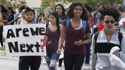 Students of Coral Glades High School, a high school less than four miles from Douglas, hold signs as the participate in a school walk for gun law change at Coral Glades High School in Coral Springs Florida on February 21, 2018. A former student, Nikolas Cruz, opened fire at Marjory Stoneman Douglas High School leaving 17 people dead and 15 injured on February 14. / AFP PHOTO / RHONA WISE        (Photo credit should read RHONA WISE/AFP/Getty Images)