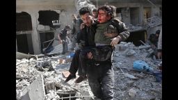 EDITORS NOTE: Graphic content / Syrians rescue a child following a reported regime air strike in the rebel-held town of Hamouria, in the besieged Eastern Ghouta region on the outskirts of the capital Damascus on February 21, 2018.  / AFP PHOTO / ABDULMONAM EASSA        (Photo credit should read ABDULMONAM EASSA/AFP/Getty Images)