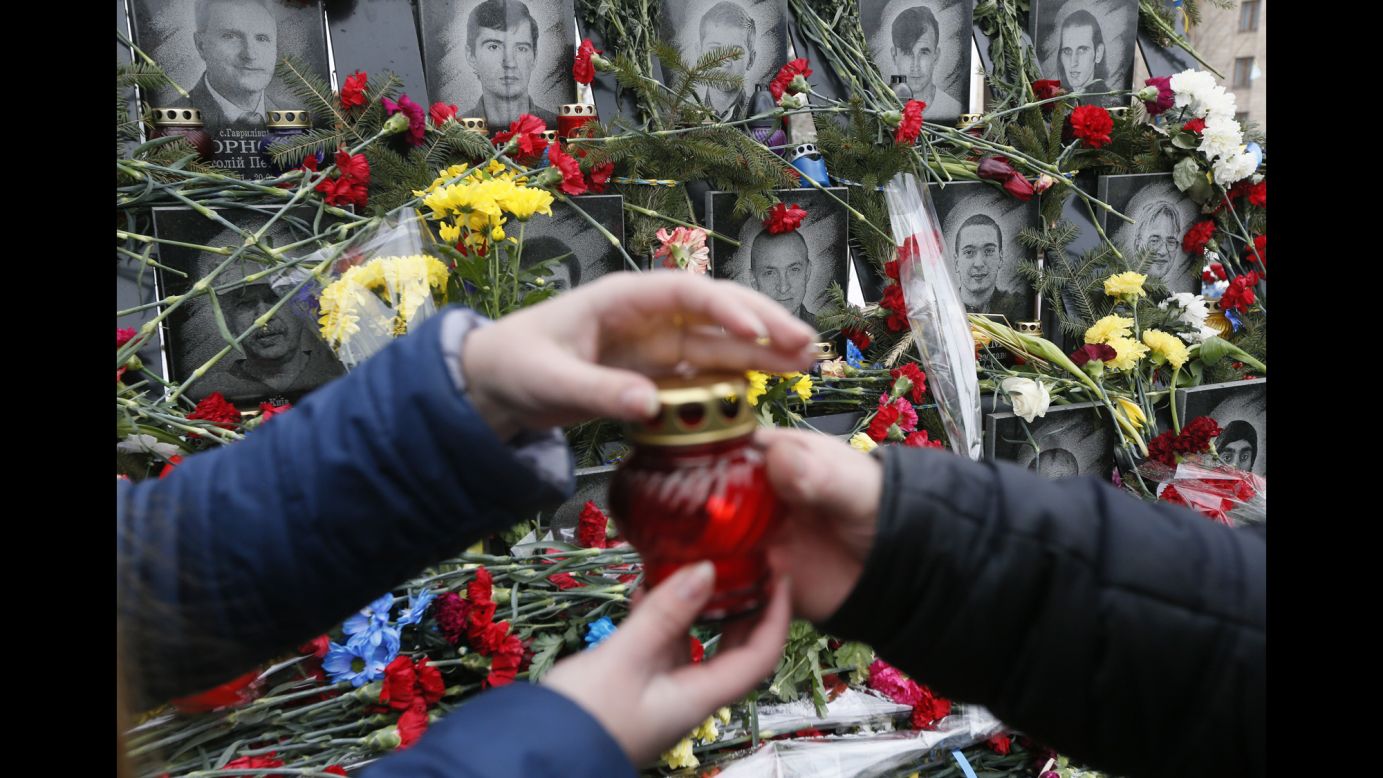 A candle is passed on Tuesday, February 20, during a commemoration ceremony at the monument to the people killed during the Ukrainian pro-European Union mass protests in 2014, in central Kiev, Ukraine.
