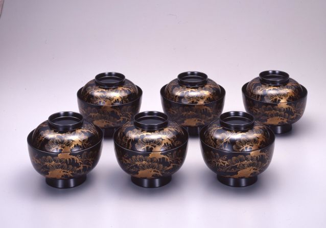 A collection of bowls decorated in the typical black and gold coloring of urushi.