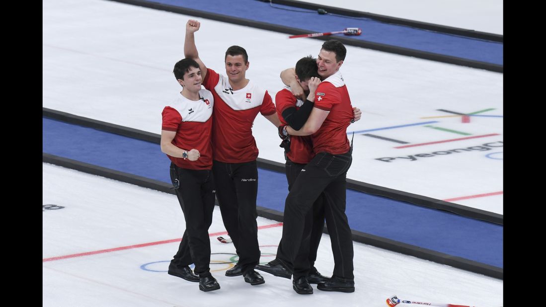 The Swiss men's curling team celebrates after winning the bronze-medal game against Canada.