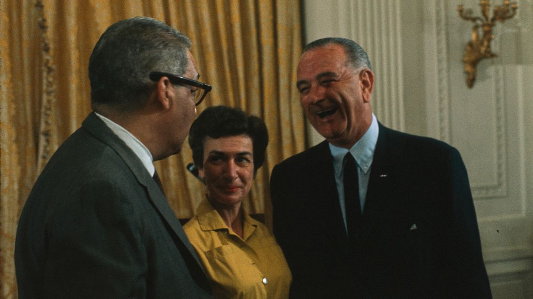 This photograph shows President Lyndon B. Johnson with Thurgood Marshall and Penelope Hartland-Thunberg at an announcement of their nominations to federal positions on July 13, 1965 in the East Room. Marshall was named solicitor general, becoming the highest-ranking African-American government official in history. Hartland-Thunberg was added to the United States Tariff Commission.