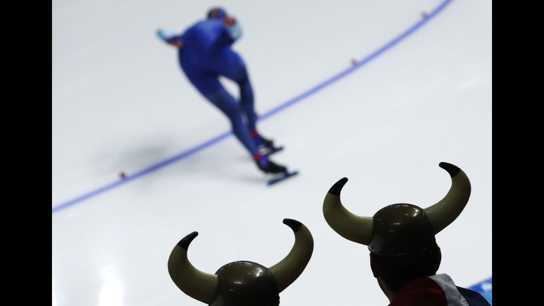 Two spectators dressed as vikings watch the 1,000-meter speedskating race.
