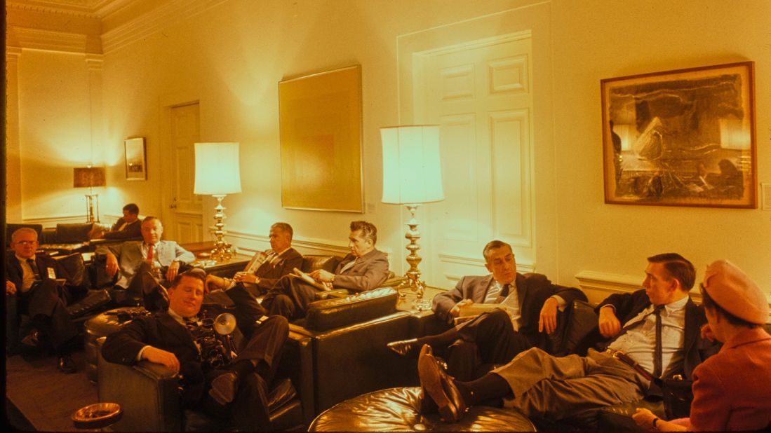 This photograph shows the press waiting in the Press Lobby in the West Wing. The press has had a dedicated work space in the White House since the construction of the West Wing in 1902, though the press area was moved around the West Wing and next door in the Eisenhower Executive Office Building before being assigned to a room built above the White House swimming pool, installed by President Franklin D. Roosevelt in 1933, during the Richard M. Nixon administration.