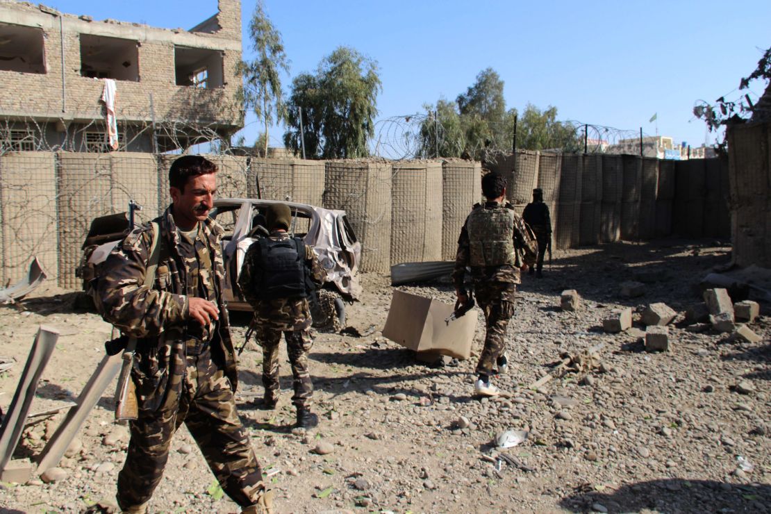 Afghan security personnel examine the site of a car bomb attack in Lashkar Gah on Saturday.