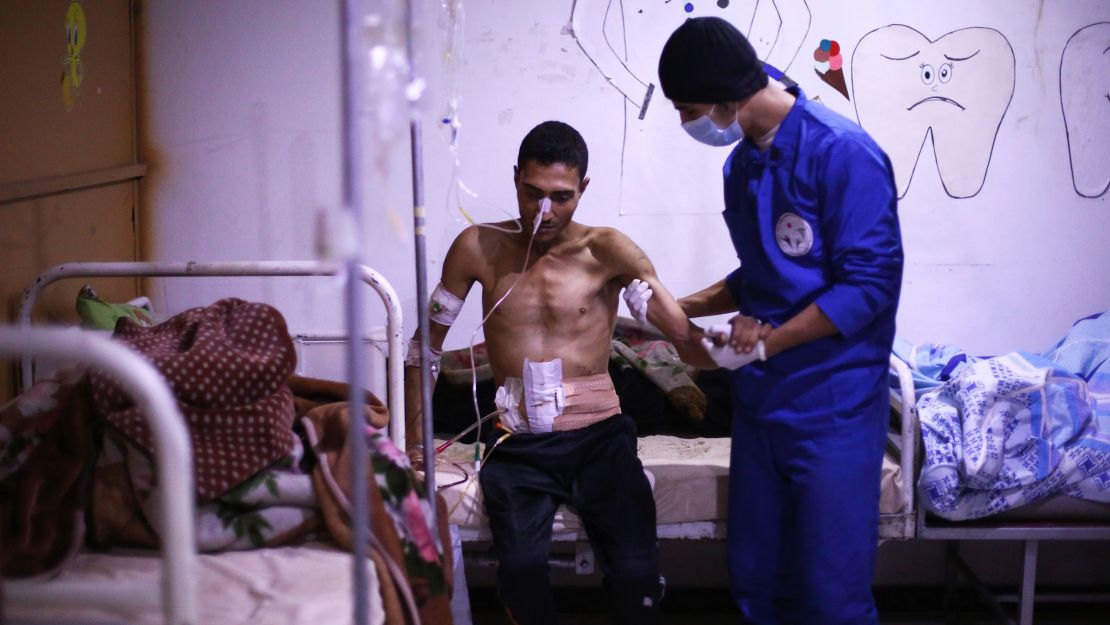 A medic assists a Syrian man who was wounded in airstrikes in Eastern Ghouta on Sunday.