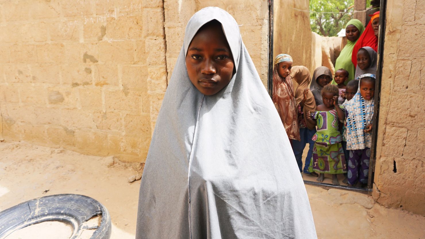 Hassana Mohammed, 13, who scaled a fence to escape a Boko Haram attack at her school, outside her home in Dapchi. 